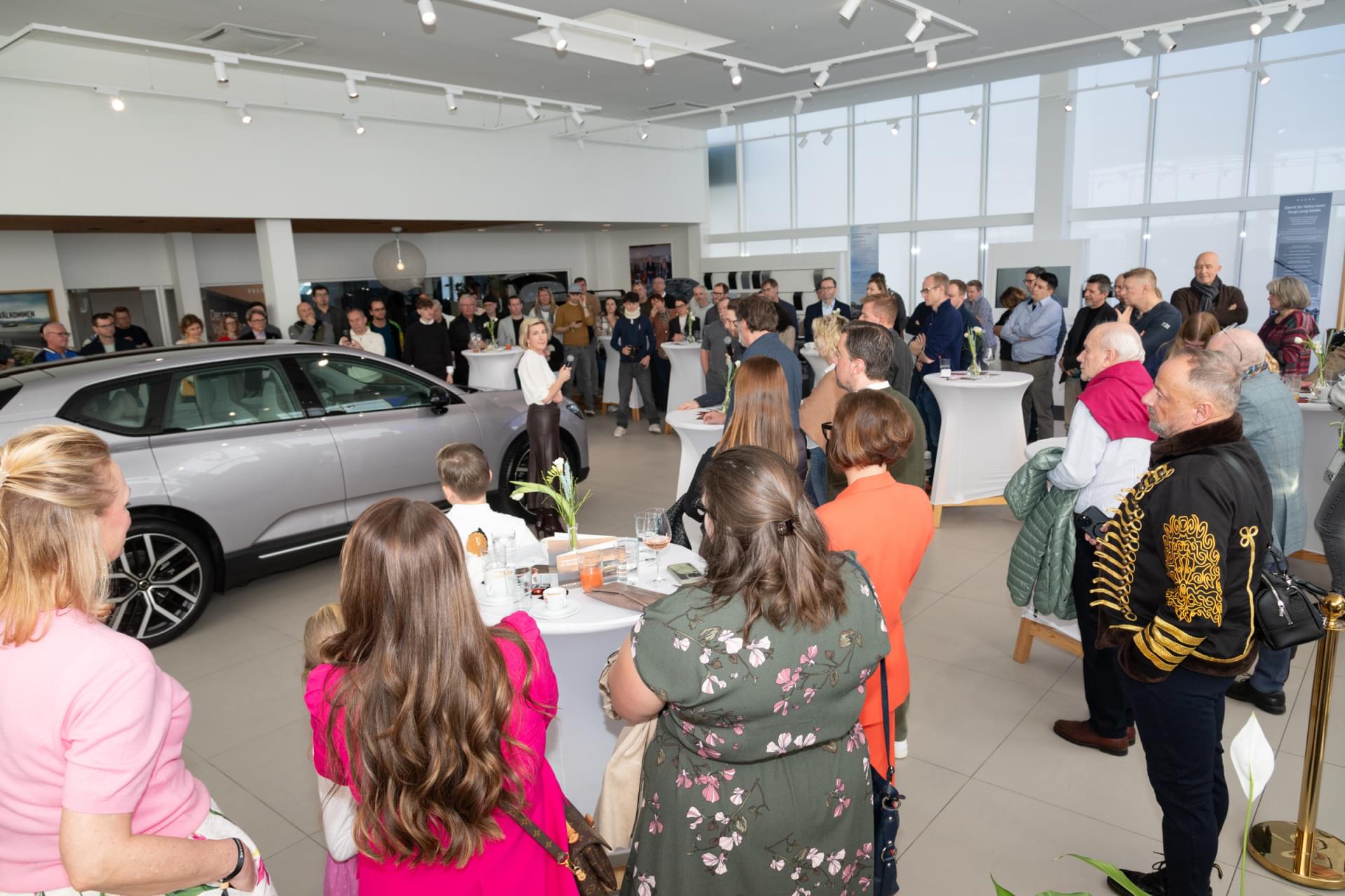 Eine Gruppe von Menschen steht um Tische mit Speisen und Getränken.